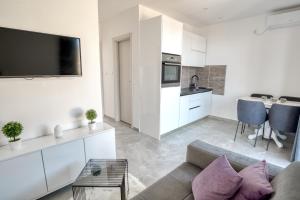 a living room with a couch and a kitchen at Apartment La Perla in Đenovići +3 photos