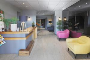 アプトにあるL'Aptois Hôtelのピンクの椅子と待合室のあるロビー