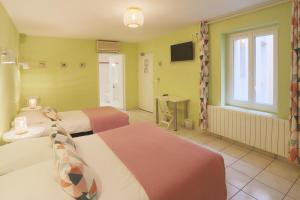 a hotel room with two beds and a television at L'Aptois Hôtel in Apt