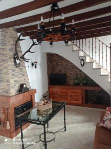 d'un salon avec une cheminée et un lustre. dans l'établissement La Posada Vivienda Turística Rural, à Algar