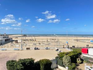 a view of a beach with people and the ocean at Les Embruns in Trouville-sur-Mer