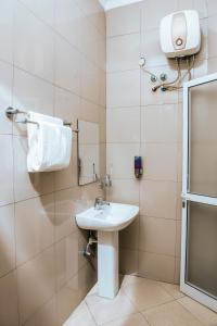 baño con lavabo, espejo y toalla en Airport Transit Lodges, en Dar es Salaam