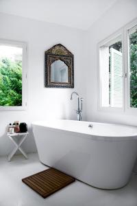 a white bath tub in a bathroom with a mirror at Residence Alouettes in Hyères