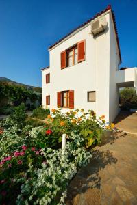 a white building with flowers in front of it at Studios Calvinos in Marathokampos +22 photos