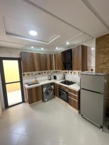 a kitchen with a refrigerator and a dishwasher at Appartement Nador Al Jadid Wifi Free in Nador