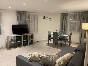 - un salon avec un canapé et une salle à manger dans l'établissement City airport serviced apartment London, à Londres