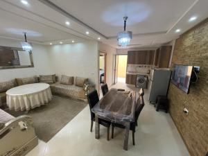 a living room with a table and a couch at Appartement Nador Al Jadid Wifi Free in Nador