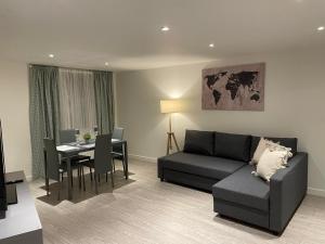 uma sala de estar com um sofá e uma mesa em City airport serviced apartment London em Londres