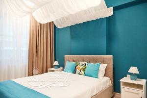 a bedroom with blue walls and a bed with a white canopy at RoApart -Sea VIEW Apartamente 2 camere la 1 min de plaja in Mamaia Nord