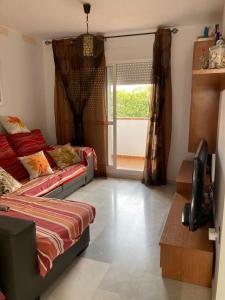 a bedroom with a bed and a television in it at Apartamento El Toyo in Almería