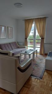 a living room with a couch and a table at Apartman MiMa in Pale