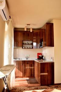 eine Küche mit braunen Holzschränken und einem Waschbecken in der Unterkunft НАПРОТИВ СПОРТИВНО-КОНЦЕРТНОГО КОМПЛЕКСА in Yerevan
