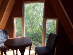 a room with a table and two chairs and a window at A-frame volledig vrijstaande woning in Hensbroek
