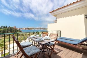 a patio with a table and chairs on a balcony at Front line townhouse n 9 in Ferragudo sea views in Ferragudo