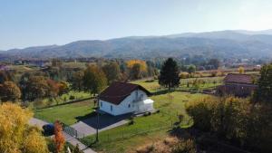 une maison blanche dans un champ avec des montagnes en arrière-plan dans l'établissement Kuća za odmor DIVA***, à Donja Stubica