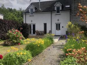a white house with flowers in front of it at Tulach Ard in Grantown on Spey