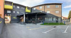 ein großes Gebäude mit einem Parkplatz davor in der Unterkunft Hostel Mali Pariz in Slavonski Brod