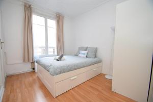 ein weißes Schlafzimmer mit einem Bett und einem Fenster in der Unterkunft Top location near ParisSuperb cosy 2p apartment in Vincennes