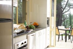 a kitchen with a sink and a stove top oven at Falls Mountain Retreat Blue Mountains in Wentworth Falls
