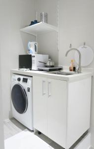 a kitchen with a washing machine and a sink at Comfy Studio 7 by ReCharge in Singapore