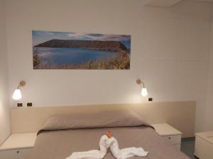 a bedroom with a bed with a painting on the wall at Lido Di Procida Guest House in Procida