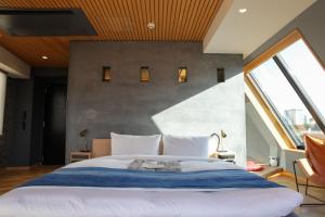 a bedroom with a large bed and large windows at Asakusa Kokono Club Hotel in Tokyo