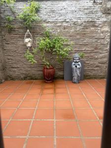 a courtyard with plants and a statue on a tile floor at Casa Inés in Trinidad