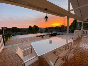 una mesa blanca y sillas en una terraza con vistas a la puesta de sol en VILLA LUISA, en Cehegín