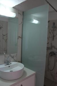 a white bathroom with a sink and a shower at Villa Angela in Istron