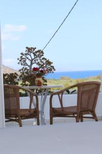 una mesa y sillas en un balcón con vistas al océano en Villa Angela, en Istron