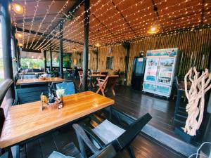 un ristorante con tavolo e sedie in legno di ViVi Hotel Resort a Phuket