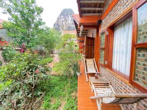 a porch of a house with chairs and trees at Tam Coc Friendly Homestay in Ninh Binh