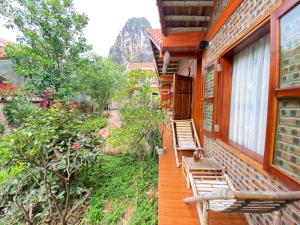 ganek domu z krzesłami i drzewami w obiekcie Tam Coc Friendly Homestay w mieście Ninh Binh