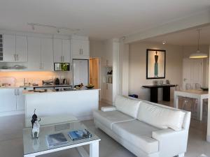 uma sala de estar com um sofá branco e uma mesa em Stella Maris Luxury Apartment em Plettenberg Bay