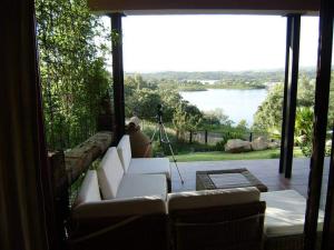 salon z kanapą i widokiem na jezioro w obiekcie Casa con encanto frente al lago w mieście El Ronquillo