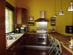 a kitchen with a stainless steel stove and a sink at Casa con encanto frente al lago in El Ronquillo