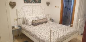 ein weißes Bett mit Kissen auf dem Zimmer in der Unterkunft shohamseaview in Eilat