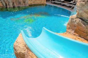 a swimming pool with a slide in the water at Menada Apartments in Karolina in Sunny Beach
