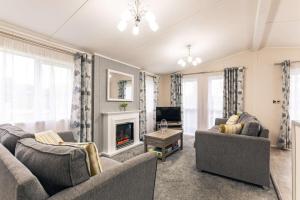 a living room with two couches and a fireplace at Moore Lodge with Hot Tub in Barmby on the Moor