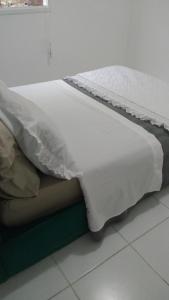 Mangaratiba Porto Real Suíte في مانغاراتيبا: سرير عليه بطانية بيضاء