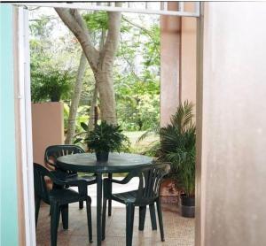 een patio met een tafel en stoelen en een boom bij Brisas de Borinquen in Aguadilla
