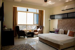 a bedroom with a large bed and a living room at Qasayed Hotel فندق قصائد in Salalah +69 photos