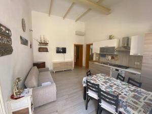 una cucina e un soggiorno con tavolo e divano di Casa Garito Teresa a Lampedusa