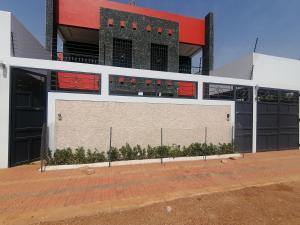 a large building with a wall with red windows at RÉSIDENCE HÔTELIÈRE KAWEROU in Ouagadougou