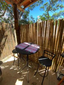 a picnic table and two chairs on a patio at Casa Estúdio com cozinha completa - Centro Serra do Cipó in Serra do Cipo