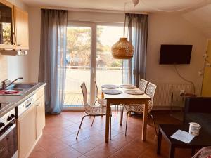 a kitchen and dining room with a table and chairs at Ferienwohnungen am Badesteig - dem Strand so nah in Dierhagen