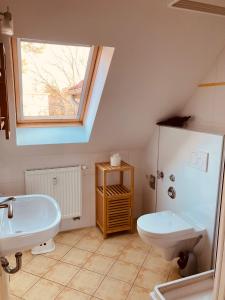 bagno con lavandino, servizi igienici e finestra di Ferienwohnungen am Badesteig - dem Strand so nah a Dierhagen