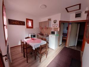 a kitchen and dining room with a table and chairs at STD Kuća Talija in Kalna