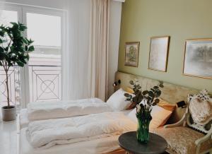 a bedroom with two beds and a vase of flowers on a table at Anna apartment in Subotica