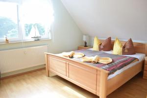 オストゼーバート・ディアーハーゲンにあるFerienwohnungen am Badesteigのベッドルーム1室(大型ベッド1台、木製家具付)